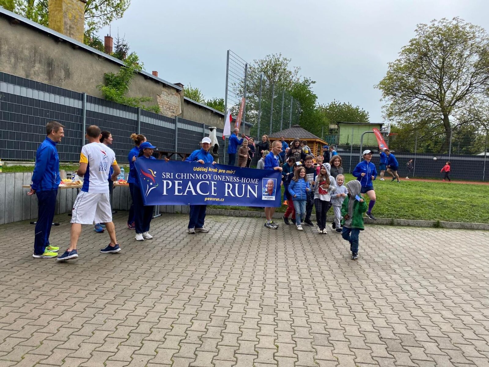 Zdjęcie przedstawia grupę biegaczy trzymających baner Peace Run
