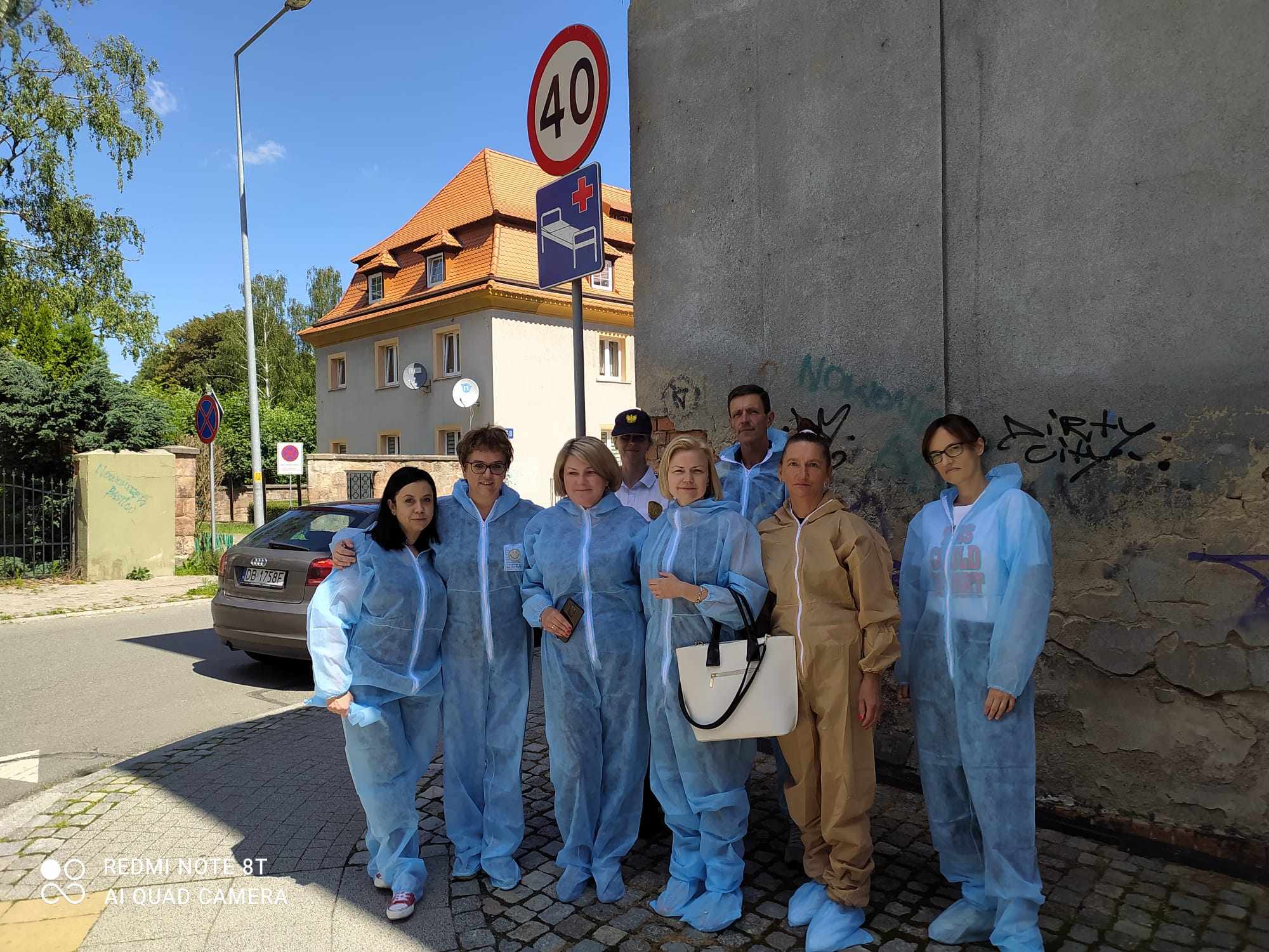 Na zdjęciu widać grupę osób przebranych w kombinezony, gotowych do malowania w dzielnicy Nowe Miasto